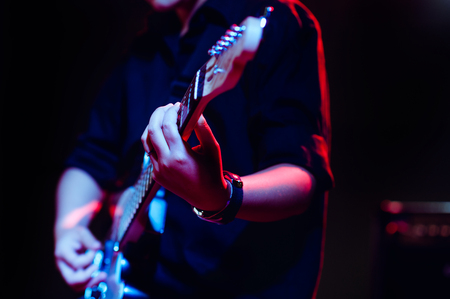 man playing guitar on a stage musical concert close-up view.guitarist plays.の写真素材