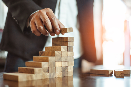 plan and strategy in business.risk concept.hand of man has piling up and stacking a wooden block.Businessman Building The Success.の写真素材