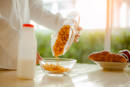 The woman poured cornflakes into a bowl. Morning concept.Wake up early.Fresh morningの写真素材