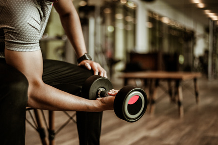 Bodybuilder working out with dumbbell weights at the gym.man bodybuilder doing exercises with dumbbell. Fitness muscular bodyの写真素材