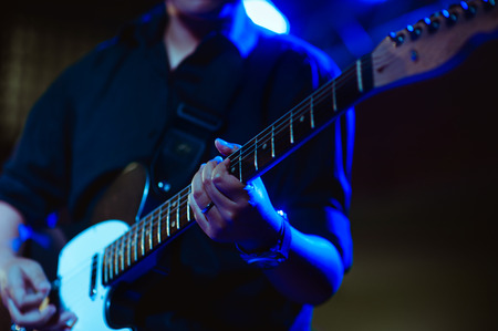 man playing guitar on a stage musical concert close-up view.guitarist plays.の写真素材