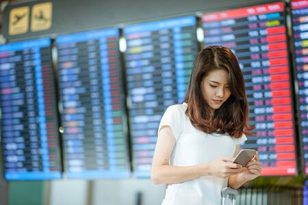 Women are using their smartphones to Flight Checking at airports.airports and technology conceptの写真素材