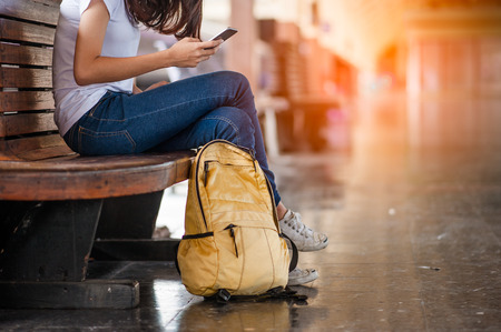 Traveler woman  waits train on railway platform.の写真素材