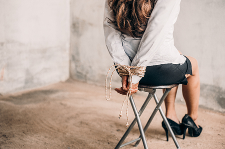 woman hands bound. Women were handcuffed and Sitting on a chair.woman tied hand to a chair.Crime Concept.Criminality Concept. Bonded business.の写真素材