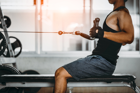 young man making low cable pulley row seated.Concept of healthy lifestyle.  bodybuilder in the gym.の写真素材