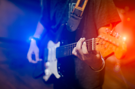 man playing guitar on a stage musical concert close-up view.guitarist plays.の写真素材