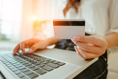 Hands holding credit card and using laptop. Online shoppingの写真素材