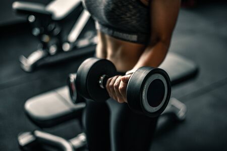 Bodybuilder working out with dumbbell weights at the gym.の写真素材