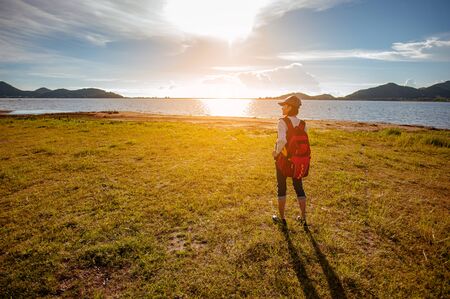 Young couple asian in a wide field is walking on foot to explore the forest as a holiday activity in...