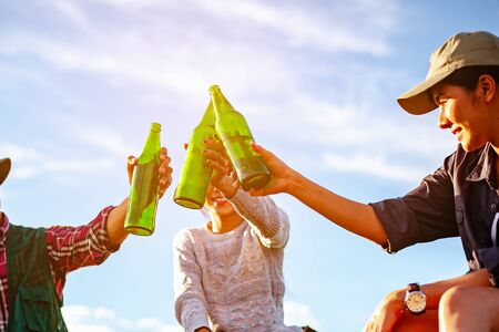 Team of asian climbers hiker are sitting and enjoying a drink after a set up outdoor tent in the forest path autumn season. Hiking, hiker, team, forest, camping , activity concept.の写真素材