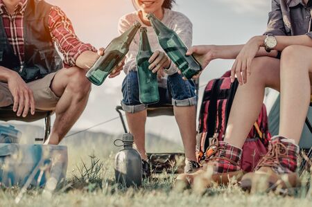  group of tourists clinking beer bottles in camping.adventure, travel, tourism, friendship and people concept.の写真素材