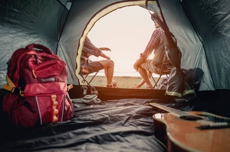 man and woman sitting in chairs on camp.の写真素材