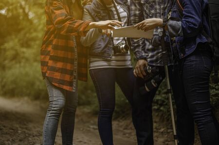 Group of young friends hiking looking at map and planning hike.の写真素材