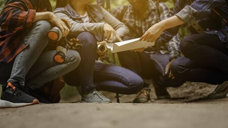 Group of young friends hiking looking at map and planning hike.の写真素材