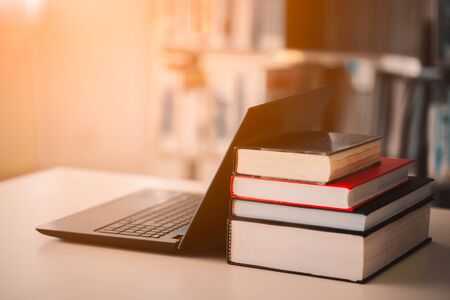 Bookshelves and laptops are placed on the library desk.E-learning class and e-book digital technologyの写真素材