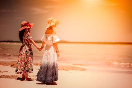 Friends is having fun against sunset beach. Beach holidays concept の写真素材