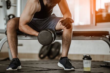 Bodybuilder working out with dumbbell weights at the gym.man bodybuilder doing exercises with dumbbell. Fitness muscular body の写真素材