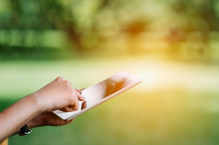 Woman touch on the screen of tablet . relaxing with digital tablet outdoor .の写真素材