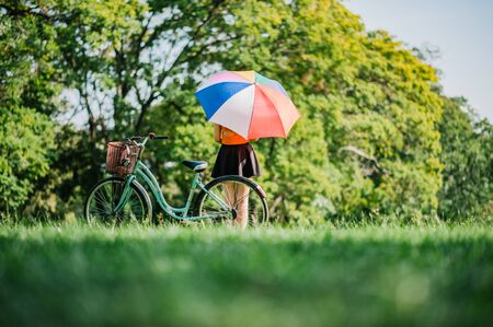 Relaxing woman at nature With colorful umbrellas and her bike.の写真素材