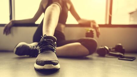 Relaxing after training.beautiful young woman looking away while sitting  at gym.young female at gym taking a break from workout.の写真素材