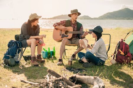 group of young people enjoy in music of drums and guitar on camping trip.の写真素材