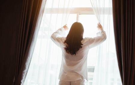 Young woman asia wake up refreshed in the morning and relax in the bedroom on holiday. Asian, asia, relax, alone, technology, lifestyle concept.の写真素材