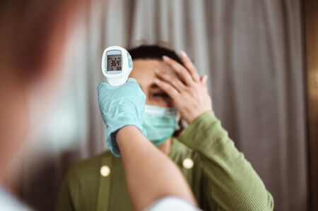 Doctor check patient body temperature using infrared forehead thermometer at hospital for Corona virus. Coronavirus, covid-19, Work from home, Social distancing, Quarantine, Prevent infection concept.の写真素材