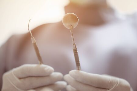 The dentist's hand holds the tooth checker and a mirror for checking and caring for the dentist's tools and equipment.
の写真素材