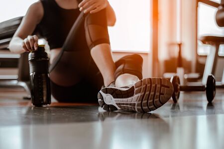 Relaxing after training.beautiful young woman looking away while sitting  at gym.young female at gym taking a break from workout.の写真素材