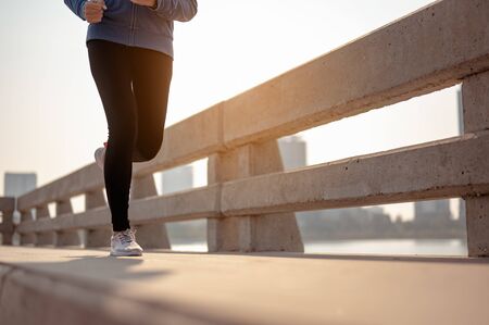 Close-up of legs young woman jogging in morning workout at the city. A city that lives healthy in the capital. Exercise, fitness, jogging, running, lifestyle, healthy concept.の写真素材