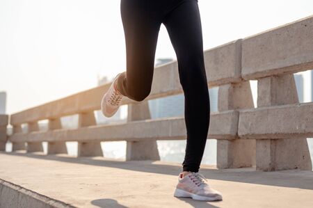 Close-up of legs young woman jogging in morning workout at the city. A city that lives healthy in the capital. Exercise, fitness, jogging, running, lifestyle, healthy concept.の写真素材