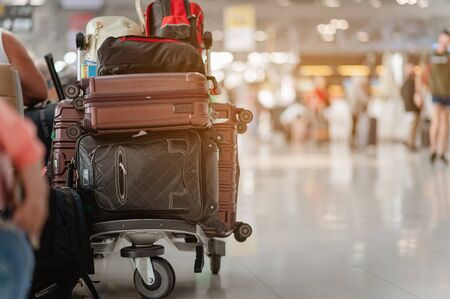Travelers are walking to drag luggage in modern airport terminal to travel to new places. Rear view. Copy space. Luggage, traveler, travel, airport, walking, holiday concept.の写真素材