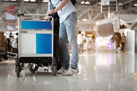 Travelers are walking to drag luggage in modern airport terminal to travel to new places. Rear view. Copy space. Luggage, traveler, travel, airport, walking, holiday concept.の写真素材