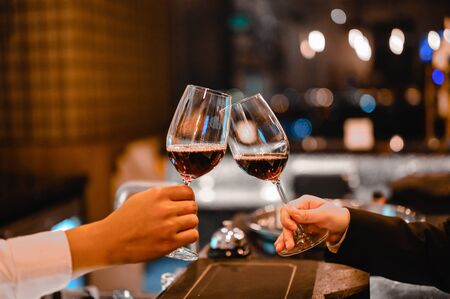 Two bartender enjoying of Cheers glass of wine for wine tasting event in a restaurant  at sunset. bartender, tasting, Dinner, Wine, beverage, dinner concept.の写真素材