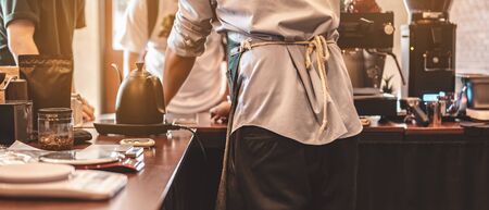 The back view of the barista in the bar counter at the coffee shop. Coffee, Barista, Bar, Cafe, deep, machine, Lifestyle concept.の写真素材