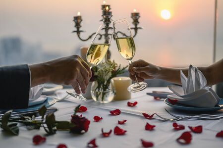 Couple enjoying of Cheers glass of wine  in a restaurant  at sunset. Valentine's, Couple, Honeymoon, Dinner, Wine, Romantic concept. の写真素材