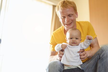 Father take toddler baby son to walk at home in holiday.の写真素材