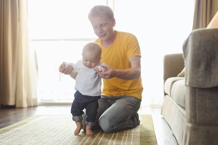 Father take toddler baby son to walk at home in holiday.の写真素材