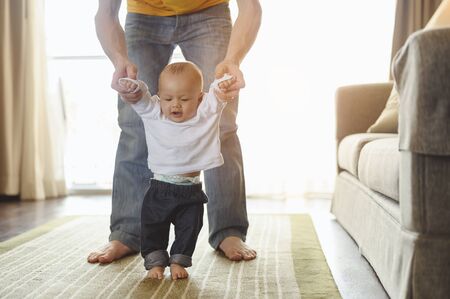 Father take toddler baby son to walk at home in holiday.の写真素材