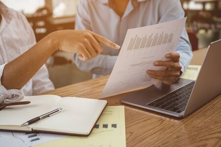 Close-ups of business people planning a new financial project on a wooden desk working in a company. Problems and concepts for solving problems.の写真素材