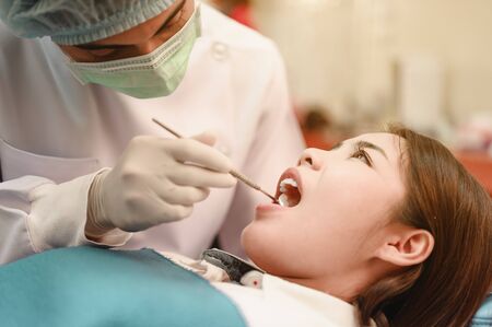 Dentist examining  teeth patients in clinic for better dental health and a bright smile.の写真素材