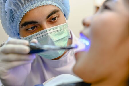 Dentist examining and filling teeth patients in clinic for better dental health and a bright smile.の写真素材