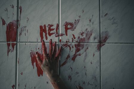Horror woman write a message requesting help with blood in hand, Halloween murder concept.の写真素材