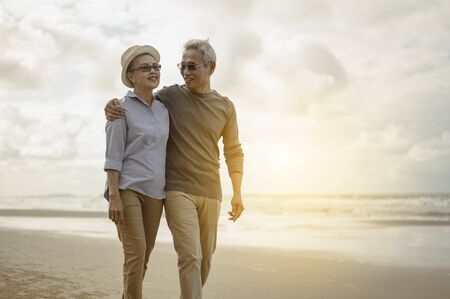 Senior couples embrace the sunset beach, plan life insurance with the concept of happy retirement.の写真素材