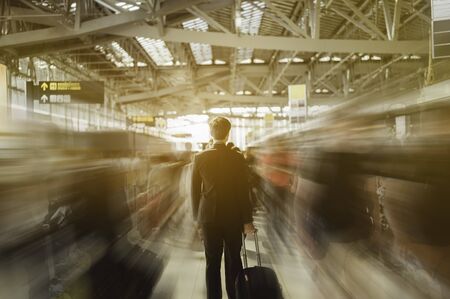 Passengers in an airport.Motion blur of walking people around businessman.の写真素材