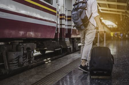 Young man traveling backpacker in train station.travel concept.の写真素材