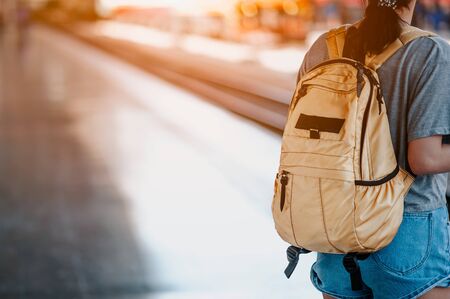Traveler woman  waits train on railway platform.