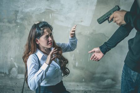 Robber with a gun robbing intimidate a woman surrender.Bandit steals from woman.Crime and robbery...