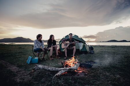 Group of friends camping.They are sitting around fire camp.の写真素材