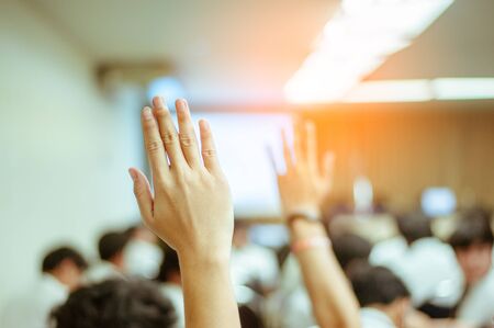  businessman raising hand during seminar. Businessman Raising Hand Up at a Conference to answer a question.の写真素材